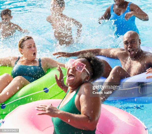 multiracial friends and family splashing on lazy river - busy lifestyle stockfoto's en -beelden