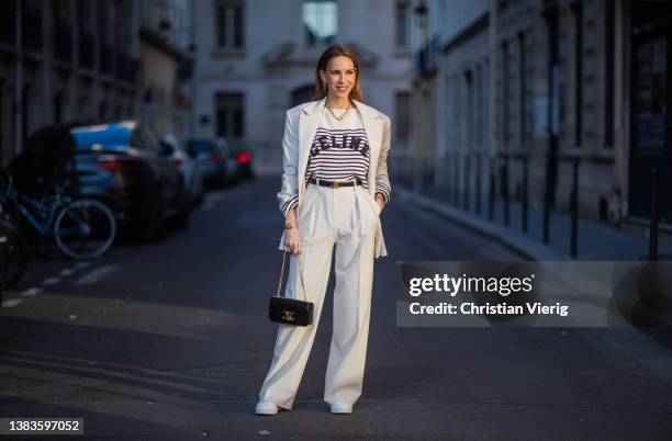 Alexandra Lapp is seen wearing PERNILLE x MANGO blazer and trousers in crème, CELINE striped jumper in crème, CELINE Triomphe bag in black, CELINE...