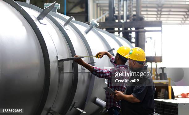 two multiracial men working in metal fabrication plant - my tablet tool stock pictures, royalty-free photos & images