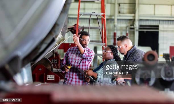 金属加工店の3人の労働者が会話する - manufacturing occupation ストックフォトと画像