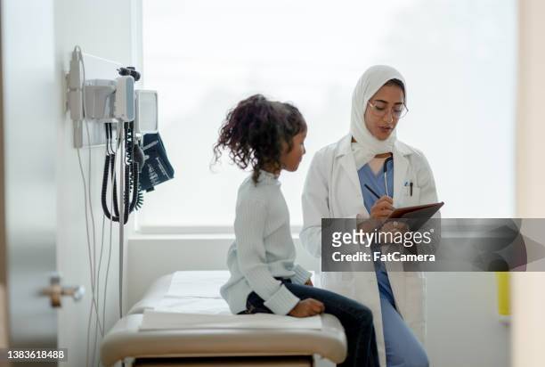 kleines mädchen bei einem check-up - arab doctor patient stock-fotos und bilder