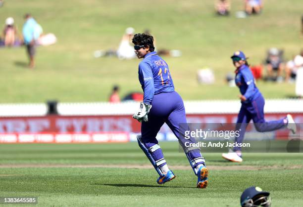 Richa Ghosh of India celebrate the wicket of Sophine Devine during the 2022 ICC Women's Cricket World Cup match between New Zealand and India at...