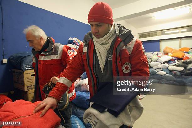 German Red Cross volunteers Adel Far and Carlo Trobisch select blankets donated for the homeless prior to making the rounds in the Waermebus, or...