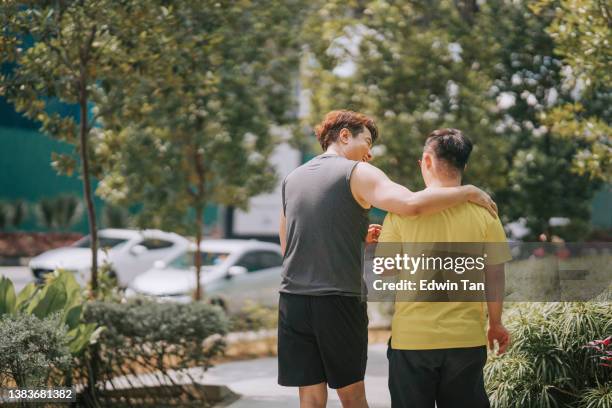 asian chinese down syndrome young man enjoying outdoor activity with his father - arm around stock pictures, royalty-free photos & images