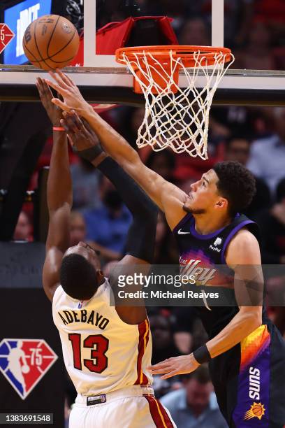 Devin Booker of the Phoenix Suns blocks a shot by Bam Adebayo of the Miami Heat during the second half at FTX Arena on March 09, 2022 in Miami,...