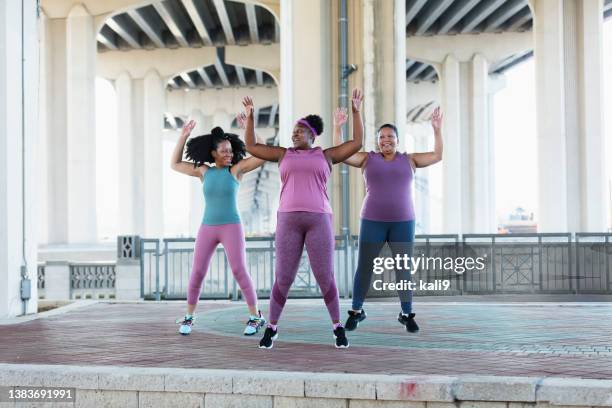 three multiracial women doing jumping jacks - star jump stock pictures, royalty-free photos & images