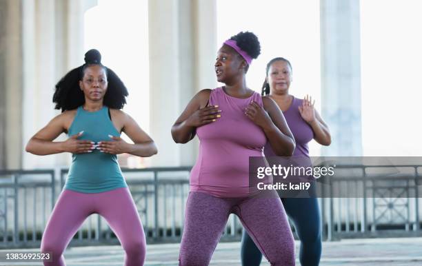 drei multirassische frauen, die tai chi im stadtgebiet praktizieren - dreiviertel vorderansicht stock-fotos und bilder