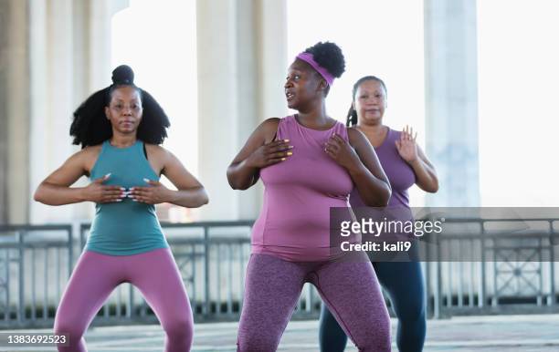 three multiracial women practicing tai chi in urban area - body shape stock pictures, royalty-free photos & images