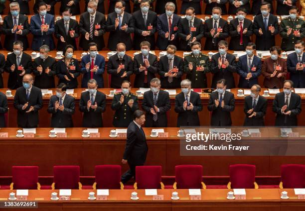 Chinese President Xi Jinping is applauded by members of the government as he arrives for the closing session of the Chinese People's Political...
