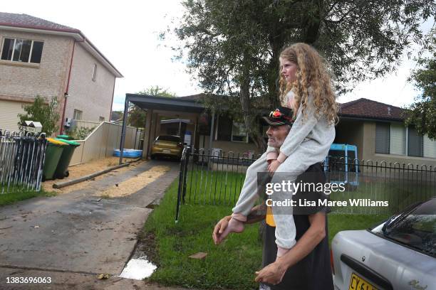 Gerry Rutterman prepares to take his daughter Kensey to a family home surrounded by floodwaters in Windsor on March 09, 2022 in Sydney, Australia....