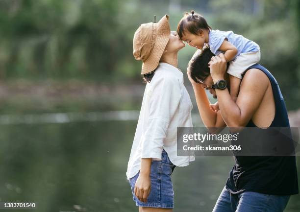 positive emotion asian family father carrying daughter on shoulders  leisure outdoor at public garden weekend activity - asian mom kid kiss bildbanksfoton och bilder