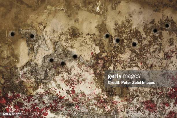 wall with bullet holes - bullet holes photos et images de collection