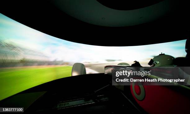 Reserve McLaren Formula One racing team driver sitting in the cockpit of a Formula One racing car simulator as he laps a digital simulation of the...