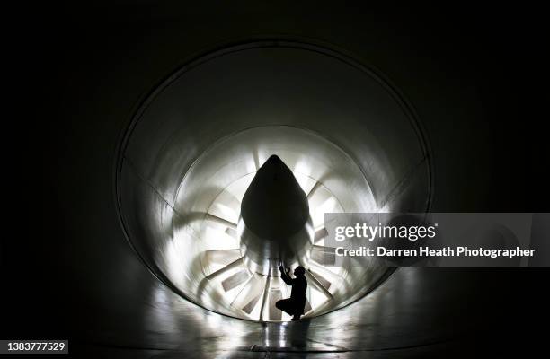 McLaren Formula One racing team aerodynamics engineer checking the underside of the wind generating turbine inside the wind tunnel of the McLaren...