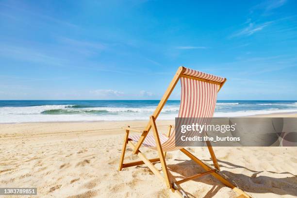 striped deck chair on beach - outdoor chair stock pictures, royalty-free photos & images