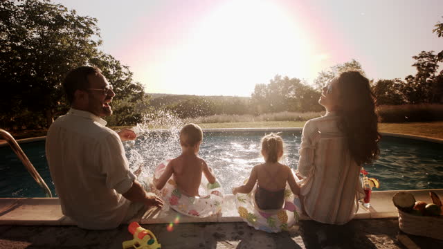 여름 날에 수영장에서 즐거운 가족.