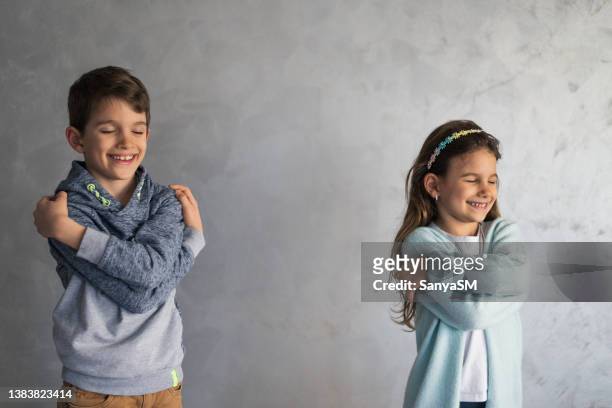 lächelnde, liebevolle kleine kinder, die sich umarmen - nur kinder stock-fotos und bilder