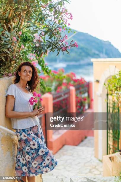 mujer joven explorando las calles de la aldea en la isla en grecia. - falda de flores fotografías e imágenes de stock