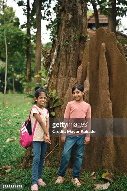 two girls standing besides a huge termite mound at coorg, karnataka - myrstack bildbanksfoton och bilder