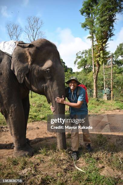 mid adult man hugs an elephant trunk at dubare elephant camp, coorg, karnataka - coorg india stock pictures, royalty-free photos & images