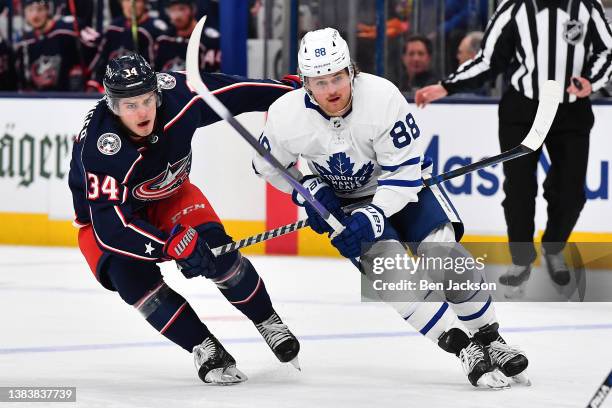 Cole Sillinger of the Columbus Blue Jackets and William Nylander of the Toronto Maple Leafs battle for position during the second period of a game at...