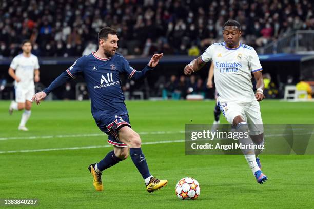 Lionel Messi of Paris Saint-Germain battles for possession with David Alaba of Real Madrid during the UEFA Champions League Round Of Sixteen Leg Two...