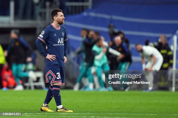 Lionel Messi of Paris Saint-Germain cuts a dejected figure as Karim Benzema of Real Madrid celebrates their sides third goal during the UEFA...