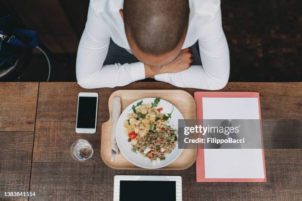 quick lunch for a young adult businessman - shaved head stock pictures, royalty-free photos & images