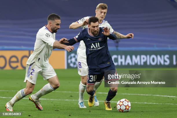Lionel Messi of Paris Saint-Germain competes for the ball with Toni Kroos of Real Madrid CF and his teammate Daniel Carvajal during the UEFA...