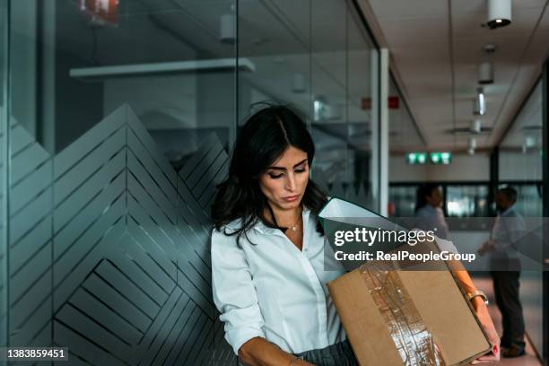 portrait à la taille d’une femme d’affaires triste tenant une boîte d’effets personnels quittant son bureau après avoir été licenciée - exclusion photos et images de collection