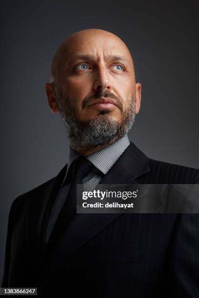 studio portrait of a middle eastern middle-aged bearded businessman posing against a dark background - handsome middle eastern men bildbanksfoton och bilder