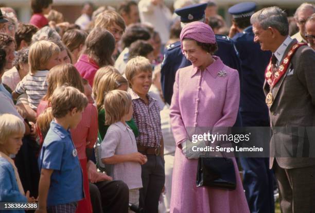 British Royal Queen Elizabeth ll, wearing a lilac suit with a checked collar and matching turban-style hat, during a walkabout in Wellington, New...