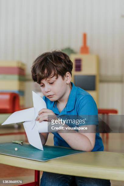 children making paper windmills in classroom - origami stock pictures, royalty-free photos & images