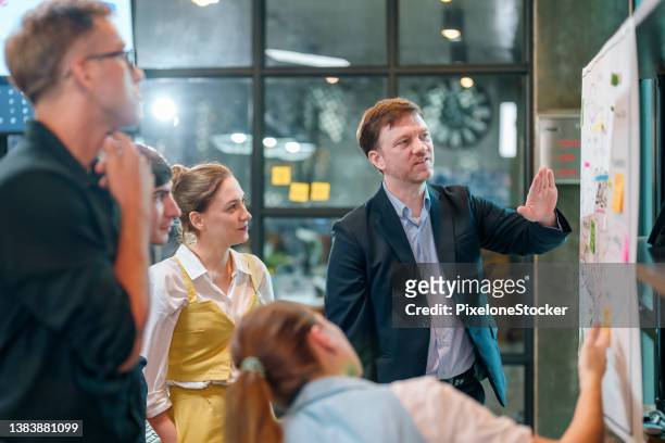 business people discussing in their office. - creative director stock pictures, royalty-free photos & images