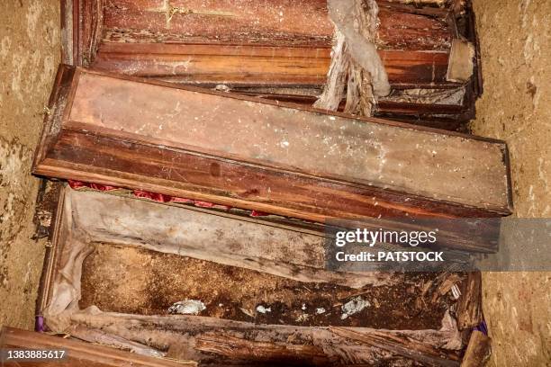 pile of old wooden coffins in an old tomb. - old coffin stock pictures, royalty-free photos & images