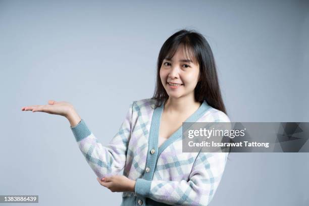 beautiful woman wearing bunny ears and presenting a copy space - woman fingers in ears stock pictures, royalty-free photos & images