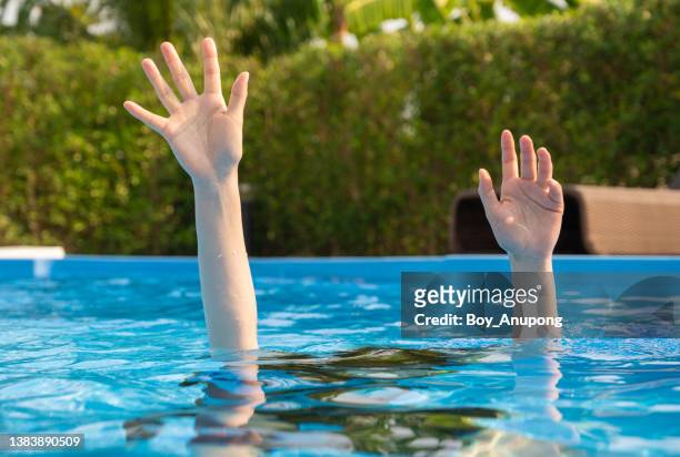 hands of person drowing in swimming pool. - drowning victim photos ストックフォトと画像