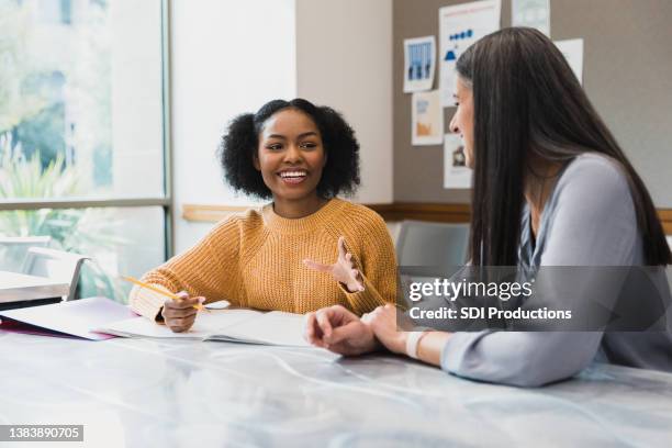 student tells a funny story to her teacher - junior high student stock pictures, royalty-free photos & images