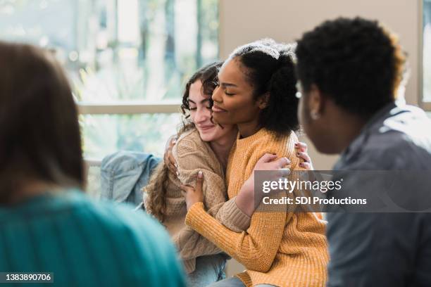 gli amici si consolano a vicenda - consoling foto e immagini stock