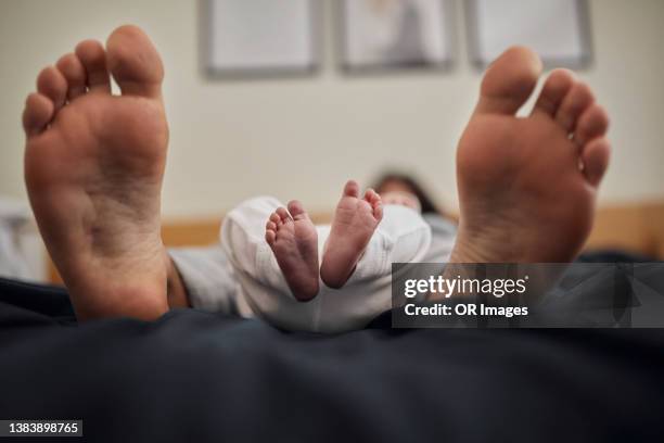 feet of father and newborn baby boy lying on bed - big foot 個照片及圖片檔