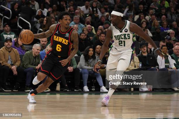 Lou Williams of the Atlanta Hawks is defended by Jrue Holiday of the Milwaukee Bucks during a game at Fiserv Forum on March 09, 2022 in Milwaukee,...