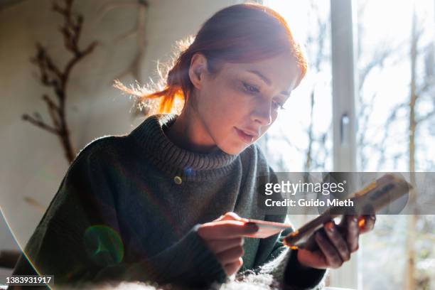 woman shopping online with laptop and credit card on hand. - credit card stock-fotos und bilder