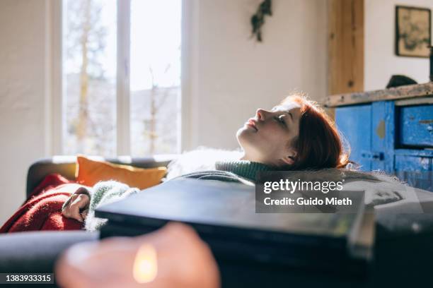 woman having a nap at home. - dormitar fotografías e imágenes de stock