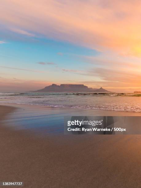 sunset glow on table mountain,scenic view of beach against sky during sunset,cape town,south africa - cape town water stock-fotos und bilder