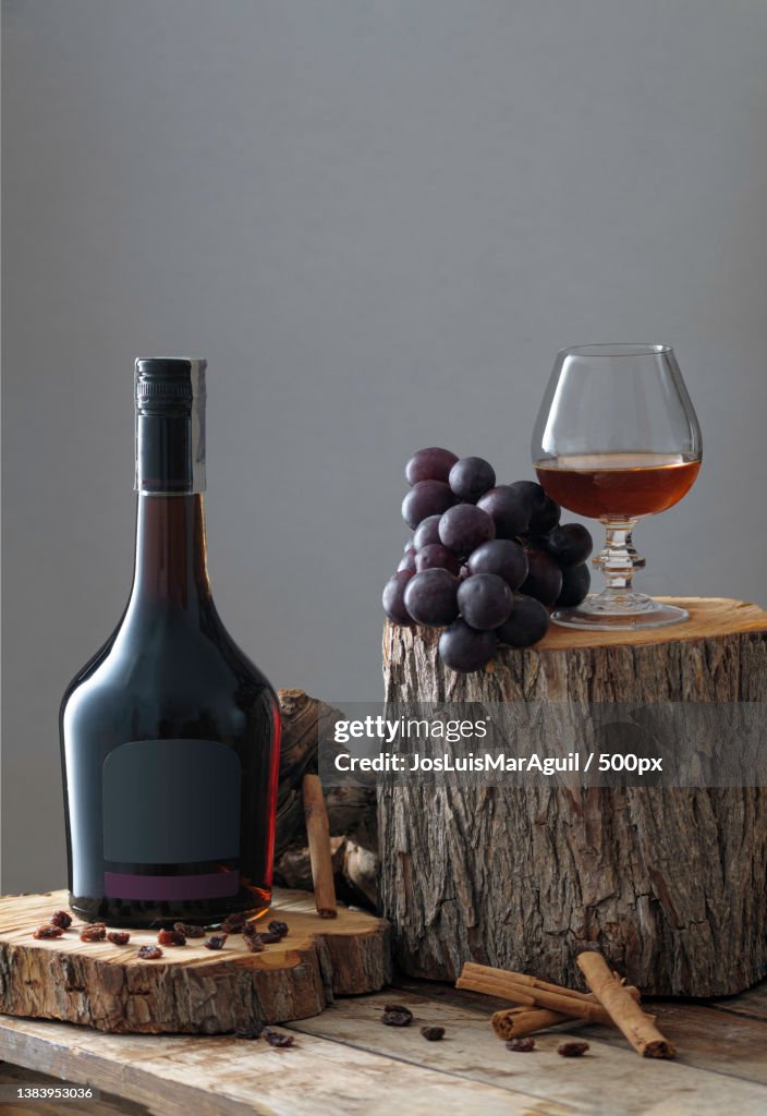 Botella y copa de brandy,Close-up of wine bottle and grapes on table