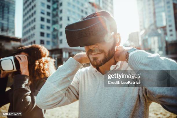 two people looking on vr goggles - vr goggles business stockfoto's en -beelden