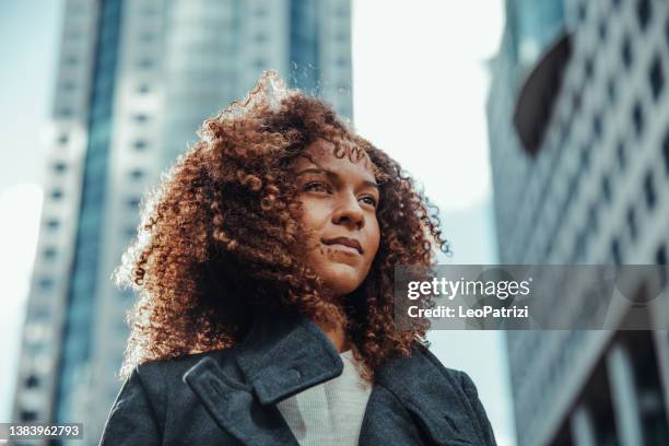 une femme d’affaires détourne le regard du bureau - african american women in the wind photos et images de collection