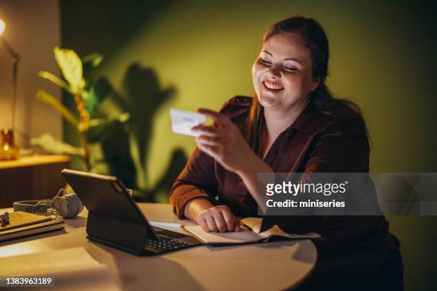 retrato de una hermosa empresaria de talla grande que compra en línea con su tarjeta de crédito - chubby credit fotografías e imágenes de stock