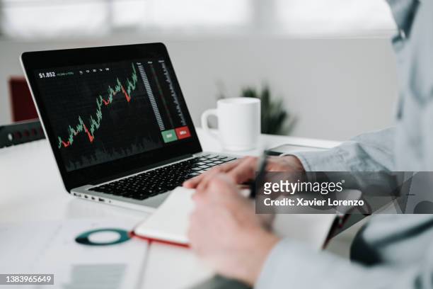 young businessman using laptop for analyzing data stock market. - beleggen stockfoto's en -beelden