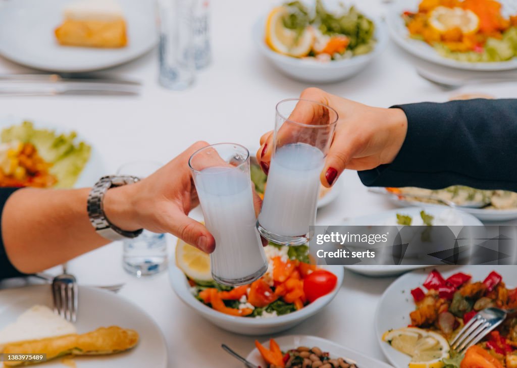 Nahaufnahme des Paares, das Spaß hat und bei einem traditionellen Abendessen mit türkischem Rakı anstößt
